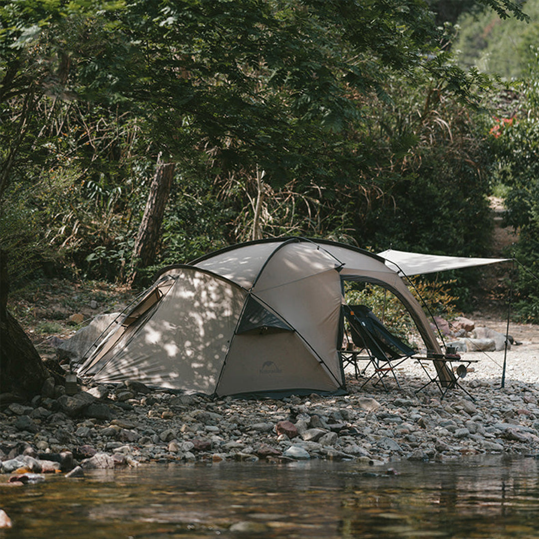 Naturehike Massif 2-Person Hot Tent set up by a lake during daytime, highlighting its full outdoor view, spacious design, and suitability for scenic all-season camping and adventure trips.