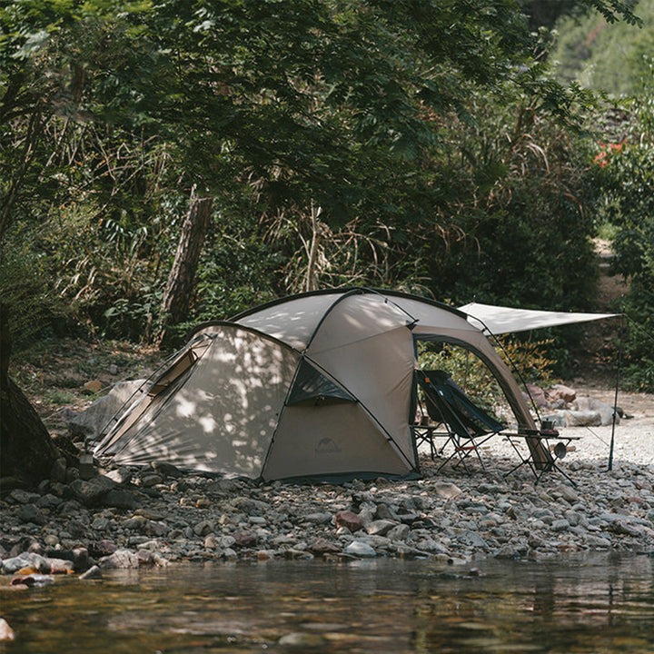 Naturehike Massif 2-Person Hot Tent set up by a lake during daytime, highlighting its full outdoor view, spacious design, and suitability for scenic all-season camping and adventure trips.