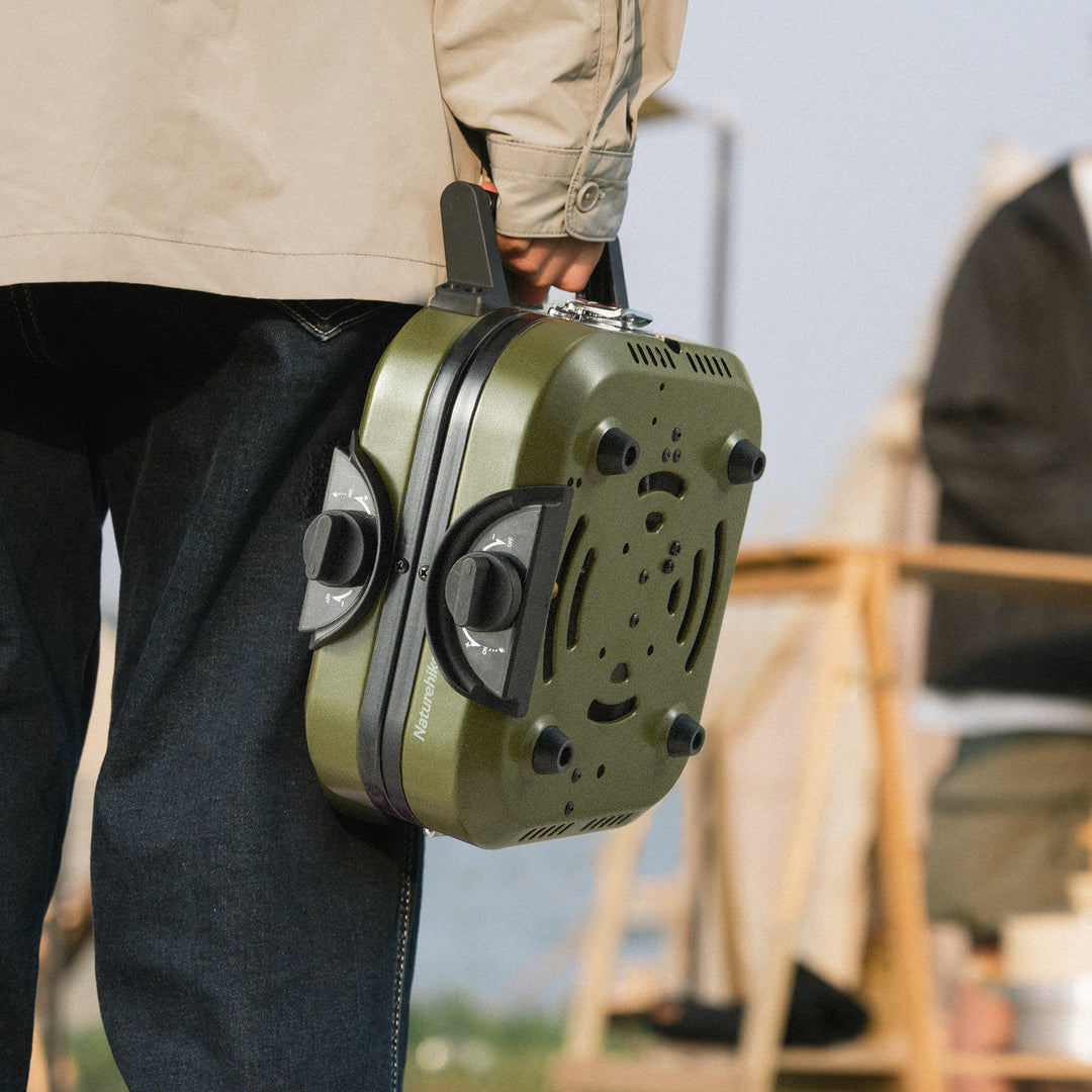 Person easily carrying the Naturehike Phantom 2-Burner Folding Camping Stove in its compact included carry bag, demonstrating its ultra-portable and lightweight design for easy transport to any outdoor adventure.