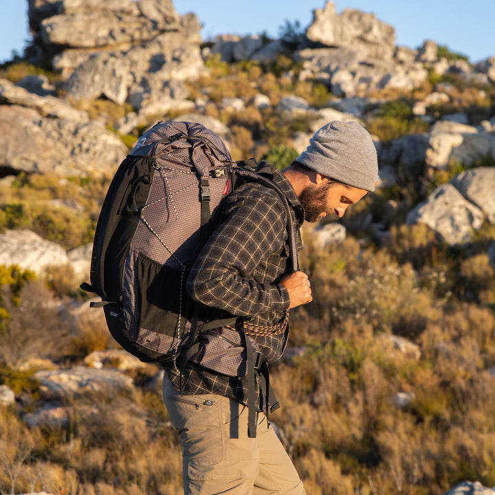 Hiker wearing Naturehike Rock 60+5L hiking backpack on outdoor trail, demonstrating extra large capacity and heavy load carrying, spacious trekking backpack ideal for multi day camping, hiking and expedition gear storage.