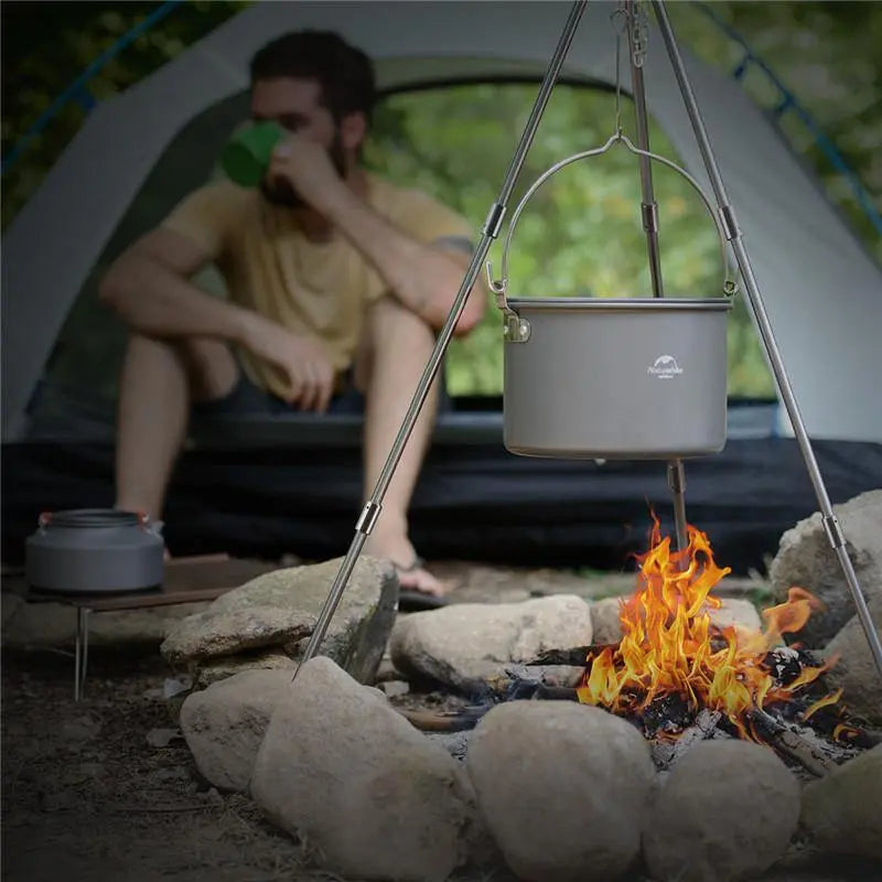 The large 4-6 Persons Aluminum Alloy Hanging Pot in use, easily suspended for preparing group meals. Highlights the ample capacity and stable design required for family camping and outdoor gatherings.